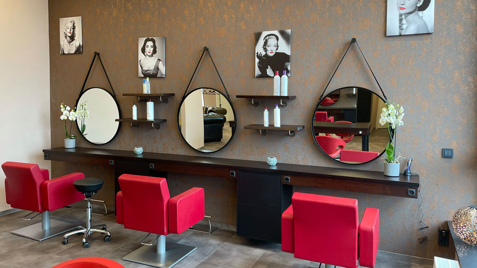Bild Frisörsalon - Kundenbereich mit roten Stühlen